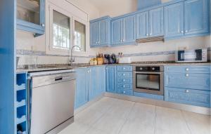 a blue kitchen with white appliances and blue cabinets at Stunning Home In L'ametlla De Mar in L'Ametlla de Mar