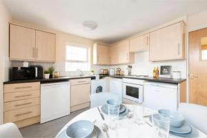 a kitchen with white cabinets and a table with chairs at For Student Only - Cable Street 10 Min Walk to Lancaster Station in Lancaster +34 photos