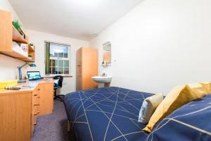 a bedroom with a bed and a desk with a laptop at For Student Only - Cable Street 10 Min Walk to Lancaster Station in Lancaster