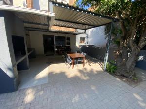 patio con tavolo in legno e sedie sotto tenda di The Hideaway a Nelspruit