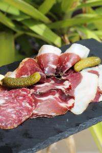 a plate of meat and vegetables on a table at Hôtel - Restaurant U Santu Petru in Saint-Florent