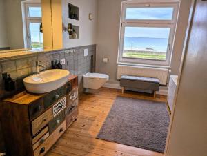 a bathroom with a sink and a toilet and a window at Haus am Meer- Traumhafter Meerblick in Dahme