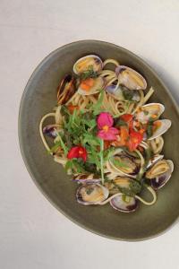 a plate of food with pasta and flowers on it at Hôtel - Restaurant U Santu Petru in Saint-Florent