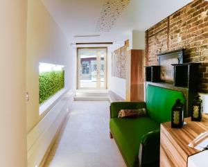 a living room with a green couch and a brick wall at Hotel Old Sarajevo in Sarajevo