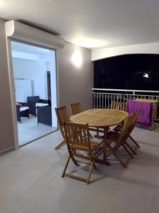 einen Holztisch und Stühle im Wohnzimmer in der Unterkunft Pink des îles in Saint-François