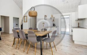 a kitchen and dining room with a wooden table and chairs at Gorgeous Home In Glesborg in Glesborg