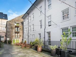 a white building with tables and potted plants at For Student Only - Cable Street 10 Min Walk to Lancaster Station in Lancaster