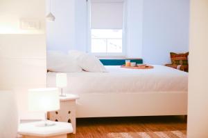 una camera da letto con un letto bianco con una finestra di Hotel Old Sarajevo a Sarajevo