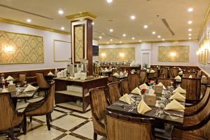 restauracja ze stołami i krzesłami w pokoju w obiekcie Garden Plaza Hotel w mieście Al-Hufuf