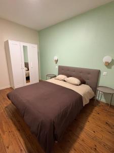 a bedroom with a bed with two tables and a mirror at Le refuge de Notre-Dame in Berck-sur-Mer