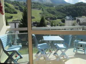 Ein Tisch und Stühle auf einem Balkon mit Aussicht in der Unterkunft Appartement à GOURETTE, résidence EURONEIGE, avec balcon, vue idéale sur la montagne - 6 personnes in Eaux-Bonnes