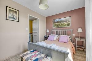 ein Schlafzimmer mit einem großen Bett mit rosa Kissen in der Unterkunft Au cœur des vignes in Montagne