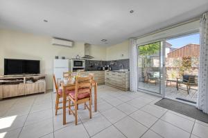 eine Küche und ein Esszimmer mit Tisch und Stühlen in der Unterkunft Au cœur des vignes in Montagne