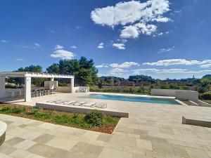 a swimming pool with lounge chairs and a patio at Residenza del Duca in Martina Franca