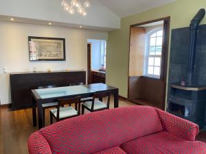 a living room with a red couch and a table at Apartamento Memória in Angra do Heroísmo