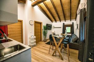 a kitchen and a living room with a table and chairs at Apartamentos O Grilo in Doade