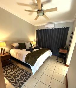 a bedroom with a bed and a ceiling fan at Fish Eagle Bay 28, Warmbaths in Bela-Bela