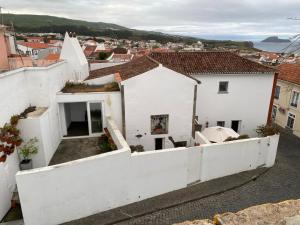 a view of a white house with a white fence at Apartamento Memória in Angra do Heroísmo