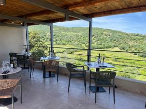 a restaurant with tables and chairs and a view of the mountains at Hôtel - Restaurant U Santu Petru in Saint-Florent
