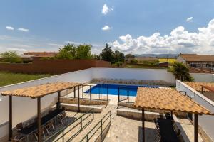 a patio with a swimming pool and umbrellas at Callejon Del Pozo in Gálvez