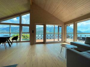 a living room with a couch and tables and windows at FjordCabin Preikestolen in Strand +31 photos