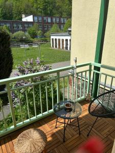 a balcony with two chairs and a table on a deck at MyHome Einsiedel an der Zwönitz 1 in Chemnitz +15 photos