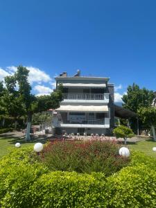 a building with a flower garden in front of it at Villa Anastasia in Leptokaria