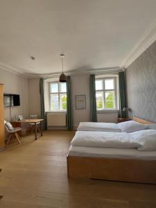 a large bedroom with a large bed and two windows at Hotel Zollhaus in Schleswig