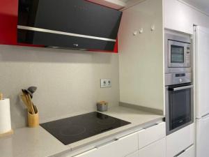 a kitchen with a stove top oven in a kitchen at Apartamento con jardín cerca playa y a 15 min de Plaza Catalunya en tren in Sant Adria de Besos