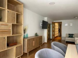 a living room with wooden shelves and a table and chairs at Apartamento con jardín cerca playa y a 15 min de Plaza Catalunya en tren in Sant Adria de Besos