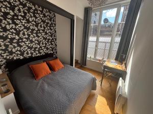 a bedroom with a bed and a large window at Le Saint André Hyper centre ville in Saint-Quentin