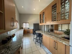 a large kitchen with wooden cabinets and a counter at Fish Eagle Bay 28, Warmbaths in Bela-Bela