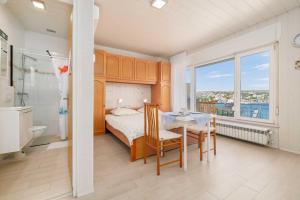a bedroom with a bed and a table and a bathroom at Studio apartment Karla with beautiful Sea view in Šilo