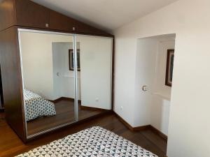 a bedroom with a glass partition with a bed at Apartamento Memória in Angra do Heroísmo