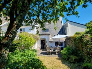 ein Haus mit einem Tisch und Stühlen im Hof in der Unterkunft Maison de pêcheur charmante pour 4 pers, 500m plage des Govelins, Saint Gildas de Rhuys - FR-1-775-24 in Saint-Gildas-de-Rhuys