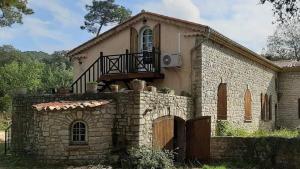 勒米伊Au bonheur de provence的一座古老的石头房子,上面设有阳台