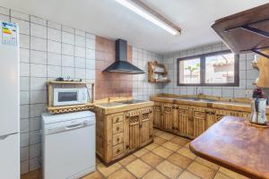 a kitchen with wooden cabinets and a white refrigerator at Callejon Del Pozo in Gálvez