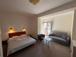 a bedroom with a bed and a couch and a table at Willa Bursztynowa 13 in Gdańsk