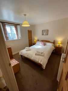 a bedroom with a bed with two towels on it at No 3 Mill Cote Cottage in Kingsbridge