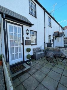 a patio with a table and chairs in front of a house at No 3 Mill Cote Cottage in Kingsbridge