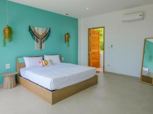 een slaapkamer met een bed en een blauwe muur bij Villa My Zen 4Br Private Pool & Walk to Beach in Chaweng Noi Beach +35 foto's