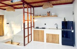 a kitchen with a black refrigerator and wooden cabinets at Villa Wild & Free in Gili Trawangan