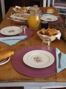 a wooden table topped with plates and baskets of food at B&B Il Gatto Pescatore in Stintino