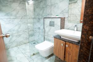 a bathroom with a sink and a toilet and a shower at Hotel The Pearl Shine in Gokarna +74 photos
