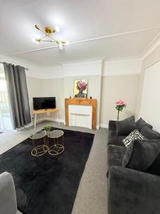 Una sala de estar con un sofá y un televisor. en Spacious 5-Bedroom house close to station, en Londres 11 fotos más