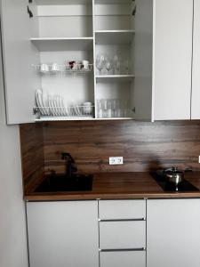 a kitchen with white cabinets and a sink and a counter at Апартаменты Aktau Rivera in Aktau