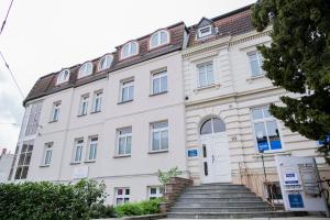 a large white building with stairs in front of it at Hans & Franz Zimmervermietung in Schwerin