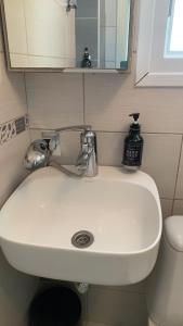 a white sink in a bathroom with a mirror at Yalos Studio in Stavros +34 photos