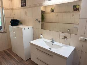 a white bathroom with a sink and a mirror at Am Stadtrand in Chemnitz +22 photos