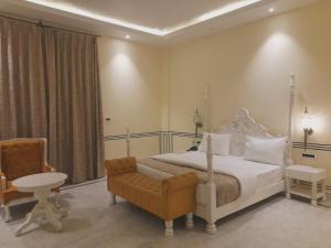 a bedroom with a white bed and a chair at Hotel Anand Bagh -Eraya Hotels in Phulera